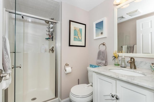 bathroom with vanity, a shower with door, and toilet