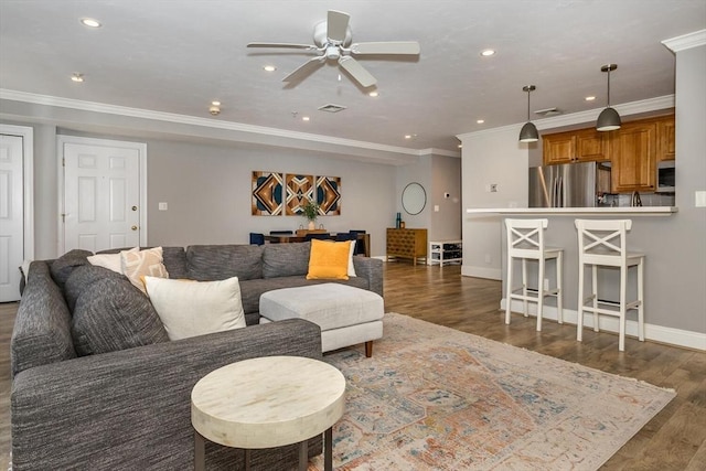 living room with dark wood-type flooring, ceiling fan, and ornamental molding