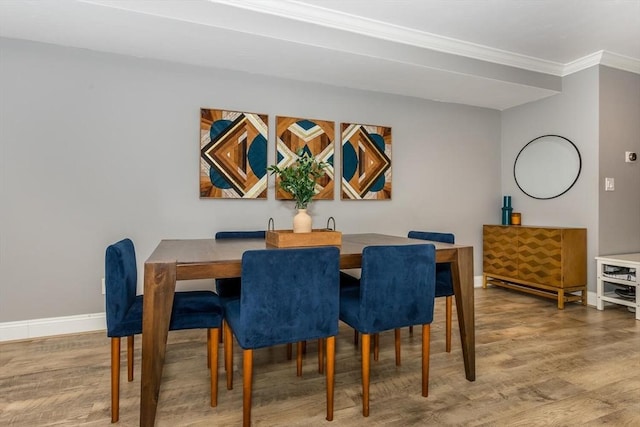 dining area with hardwood / wood-style floors and ornamental molding