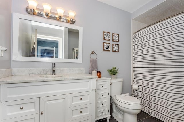 bathroom featuring vanity, a shower with shower curtain, tile patterned floors, and toilet