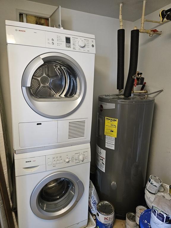 laundry room featuring stacked washer / dryer and electric water heater