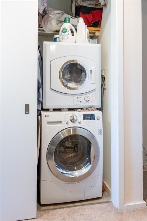 clothes washing area with estacked washer and dryer