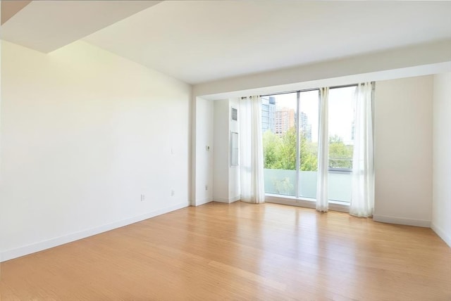 empty room with light wood-style flooring and baseboards