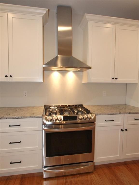 LOT4 Forest Hill Dr, Rutland, MA 01543 - kitchen featuring wall chimney range hood, light stone counters, stainless steel range with gas cooktop, light wood-style floors, and white cabinetry