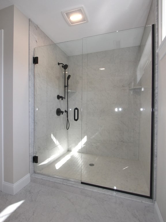 bathroom featuring a shower with door