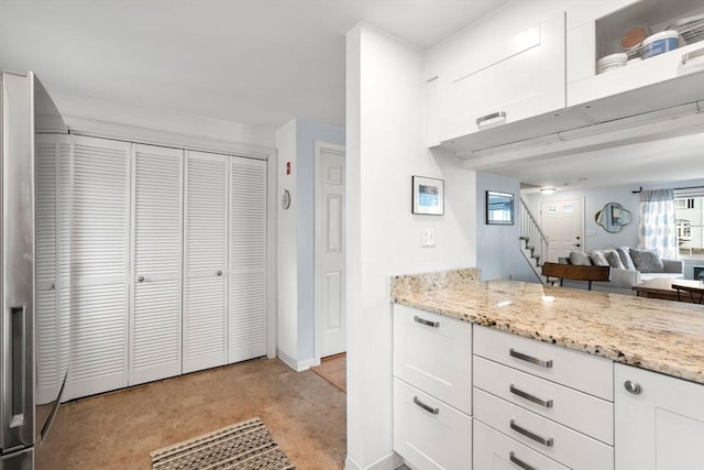 kitchen featuring plenty of natural light, white cabinets, and light stone countertops