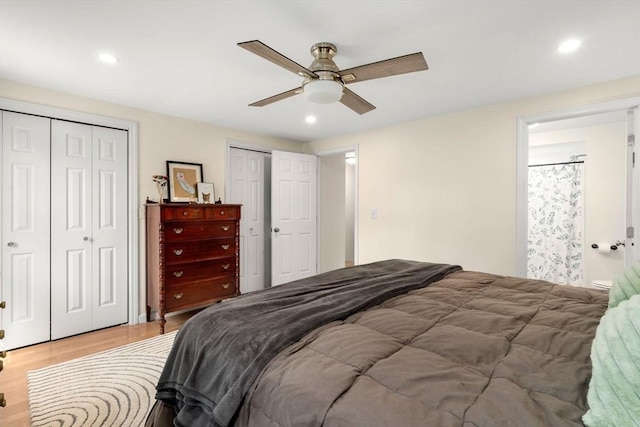 bedroom featuring recessed lighting, light wood finished floors, and multiple closets