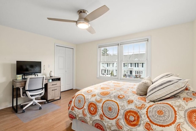 bedroom with a closet, baseboards, ceiling fan, and light wood-type flooring