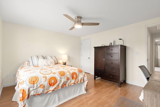 bedroom featuring baseboards, a ceiling fan, attic access, and light wood-type flooring