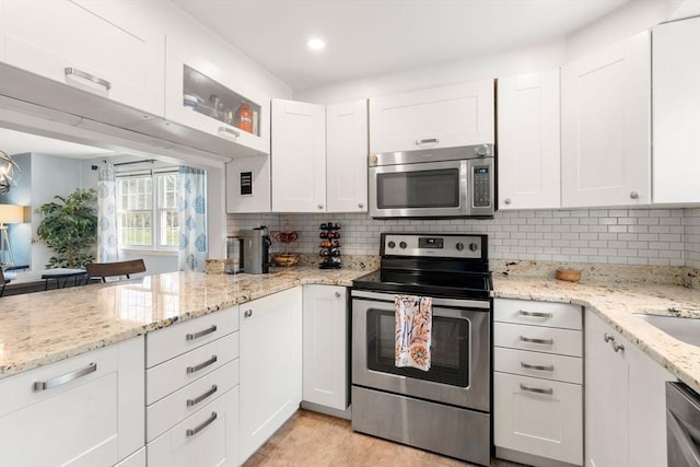 kitchen with appliances with stainless steel finishes, decorative backsplash, and white cabinetry
