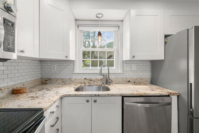 kitchen featuring a sink, white cabinets, backsplash, and stainless steel appliances
