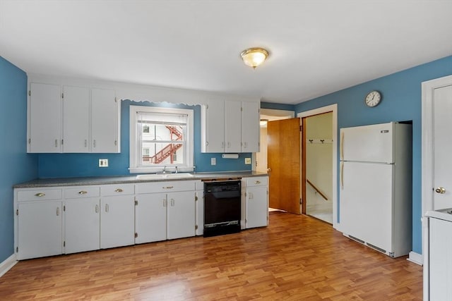 16 Elm St, Leominster, MA 01453 - kitchen with freestanding refrigerator, black dishwasher, a sink, light wood-style floors, and white cabinetry