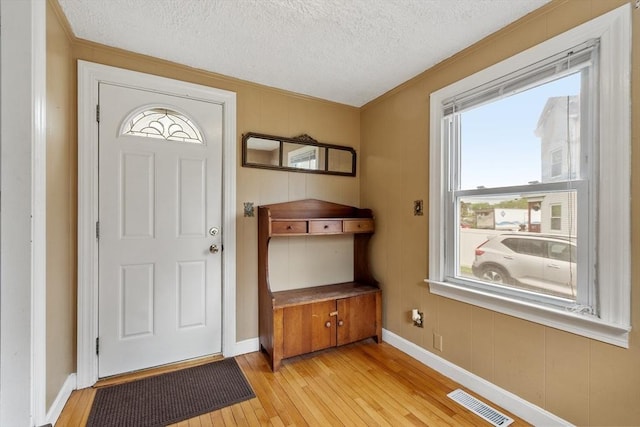 16 Elm St, Leominster, MA 01453 - entryway featuring crown molding, light wood finished floors, a textured ceiling, and baseboards