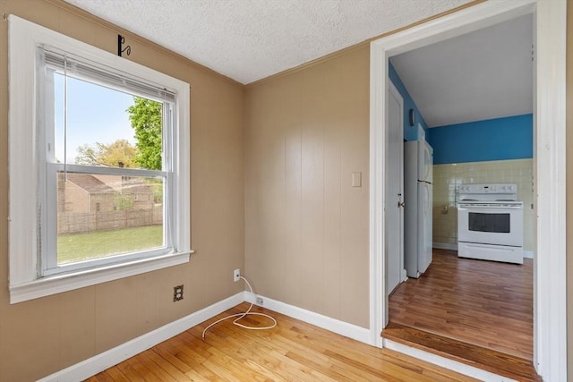 16 Elm St, Leominster, MA 01453 - spare room with wood finished floors, baseboards, ornamental molding, and a textured ceiling