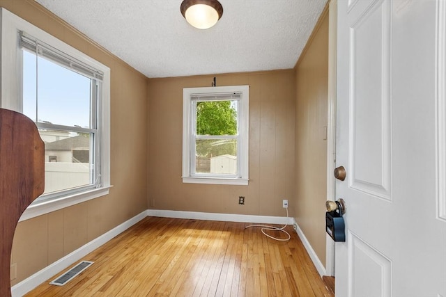 16 Elm St, Leominster, MA 01453 - empty room with light wood-type flooring, baseboards, and a textured ceiling