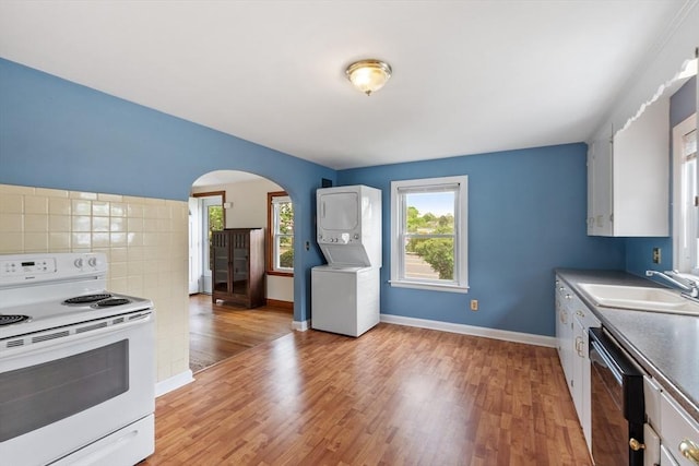 16 Elm St, Leominster, MA 01453 - kitchen featuring white range with electric cooktop, a sink, stacked washer / dryer, arched walkways, and dishwasher