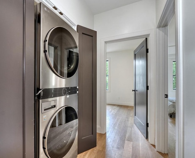 116 Moore St Unit 305, Boston, MA 02128 - laundry area featuring estacked washer and dryer, light wood-style flooring, plenty of natural light, and baseboards