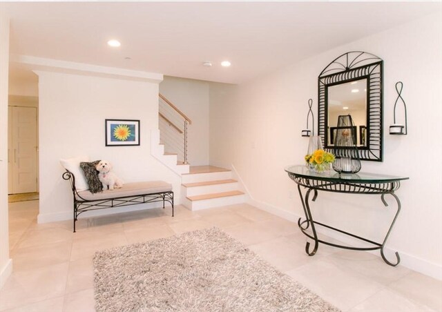 hall featuring stairway, baseboards, tile patterned flooring, and recessed lighting