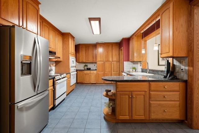 kitchen featuring white appliances, a sink, under cabinet range hood, and tile patterned flooring