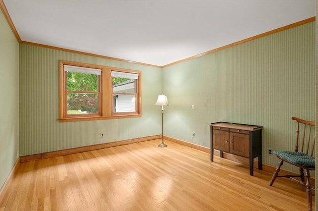 spare room featuring crown molding, wood finished floors, and baseboards