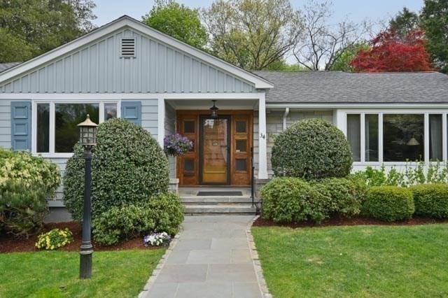 view of front of house with board and batten siding and a front lawn