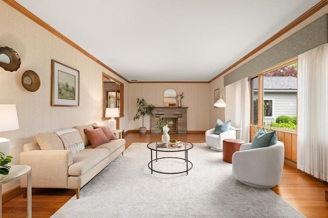 living area with ornamental molding, wood finished floors, and a fireplace