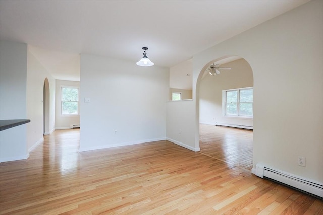 37 Annetta Rd, Ashland, MA 01721 - empty room with arched walkways, a baseboard radiator, baseboard heating, and light wood-style floors