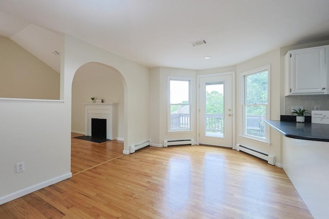 37 Annetta Rd, Ashland, MA 01721 - unfurnished dining area featuring a baseboard heating unit, light wood-type flooring, and a fireplace with flush hearth