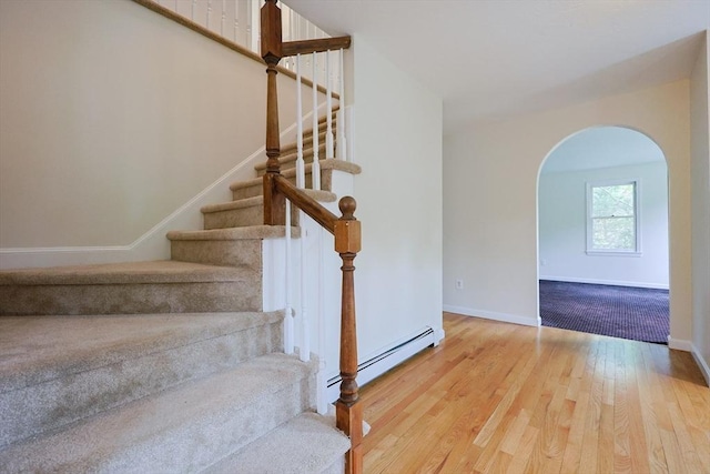 37 Annetta Rd, Ashland, MA 01721 - staircase featuring a baseboard heating unit, wood finished floors, arched walkways, and baseboards