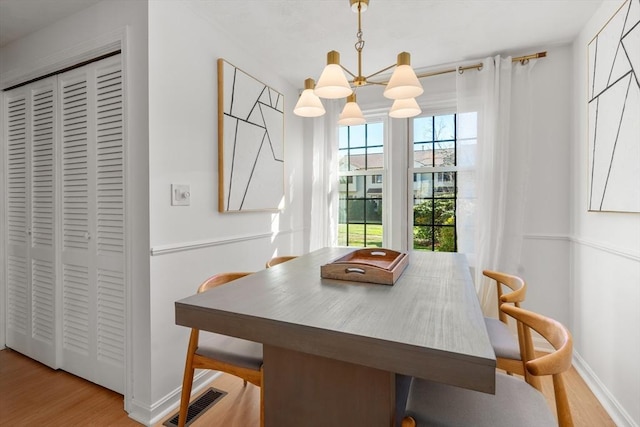 dining space featuring an inviting chandelier and light hardwood / wood-style flooring