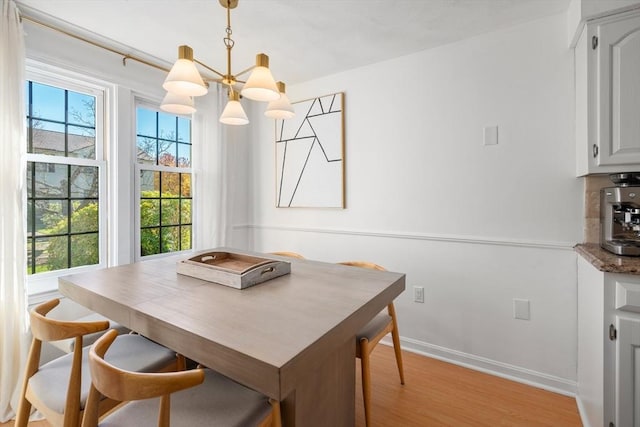 dining room featuring a chandelier, a healthy amount of sunlight, and light hardwood / wood-style flooring