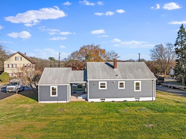 back of house featuring a yard and a chimney