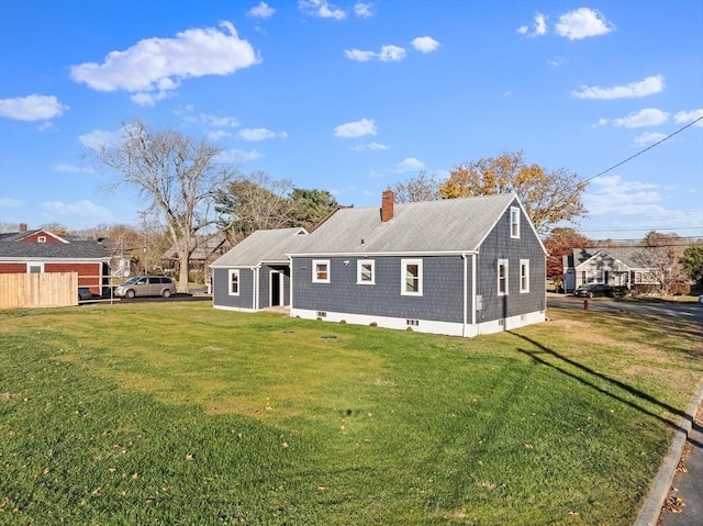 back of property featuring a chimney and roof with shingles