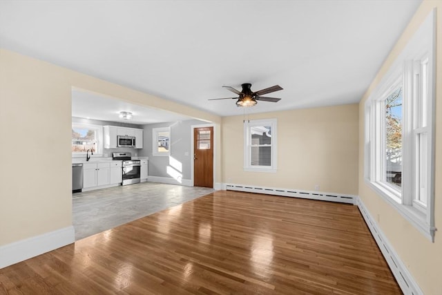 unfurnished living room with a baseboard radiator, light wood finished floors, ceiling fan, and baseboards