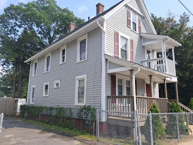 25 Clifton Ave, Springfield, MA 01105 - view of property exterior with covered porch, a chimney, a fenced front yard, and a balcony