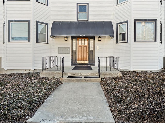 view of exterior entry with a porch and metal roof