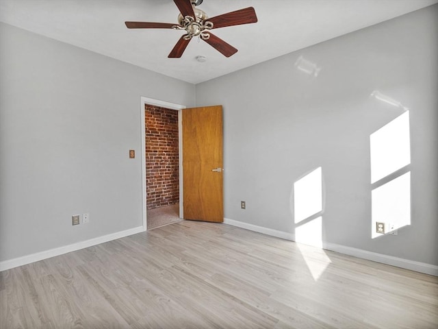 empty room featuring light wood-style floors, ceiling fan, and baseboards