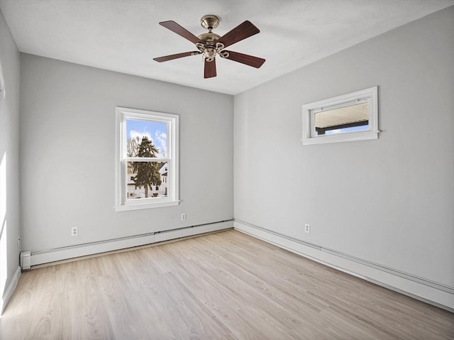 spare room featuring a baseboard heating unit, ceiling fan, and wood finished floors