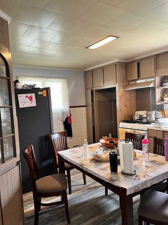 dining space with dark hardwood / wood-style flooring and ornamental molding