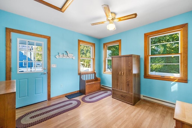 entryway featuring baseboard heating, ceiling fan, and light wood-type flooring