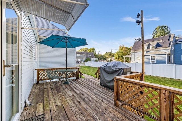 wooden deck featuring grilling area and a lawn