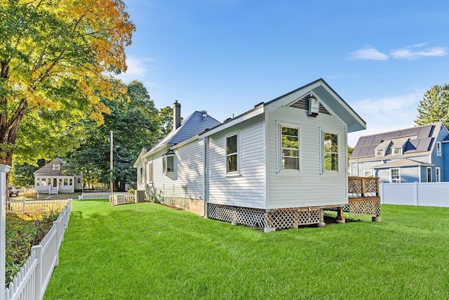 rear view of property featuring a lawn