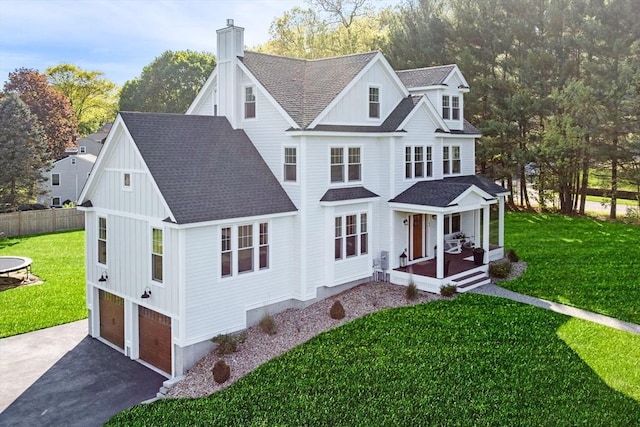 view of front facade with driveway, covered porch, a shingled roof, a garage, and a chimney