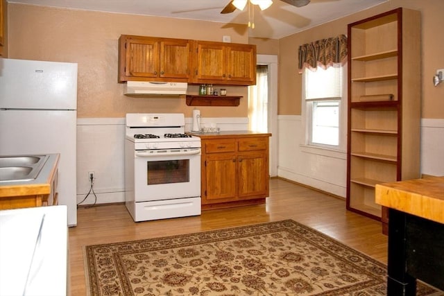 kitchen featuring ceiling fan, white appliances, and light hardwood / wood-style floors