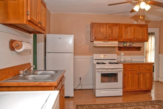 kitchen featuring sink, ceiling fan, white appliances, and light hardwood / wood-style floors