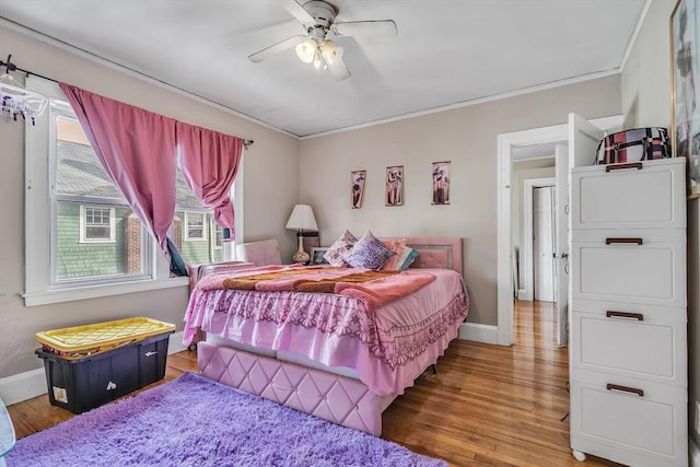 bedroom featuring hardwood / wood-style flooring, crown molding, and ceiling fan