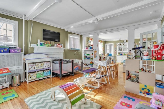 game room with hardwood / wood-style flooring, crown molding, plenty of natural light, and decorative columns