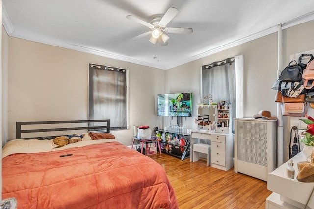 bedroom with crown molding, light hardwood / wood-style flooring, and ceiling fan