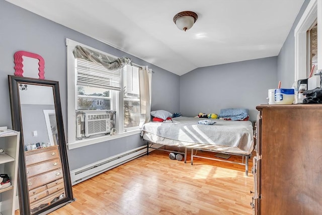 bedroom with wood-type flooring, vaulted ceiling, a baseboard heating unit, and cooling unit