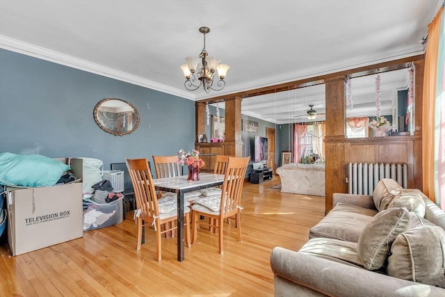 dining room with ornamental molding, radiator heating unit, and wood-type flooring